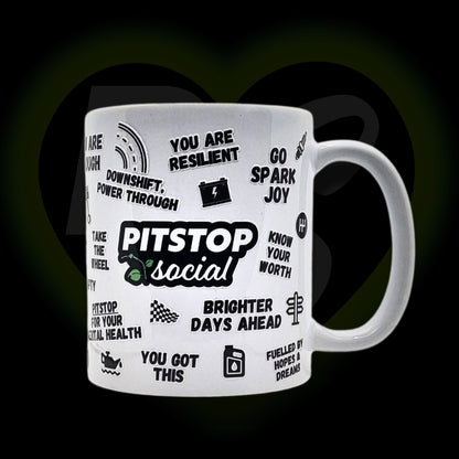 A white ceramic mug with 3D raised text and graphics including the Pitstop Social logo, various car engine warning symbols form mental health