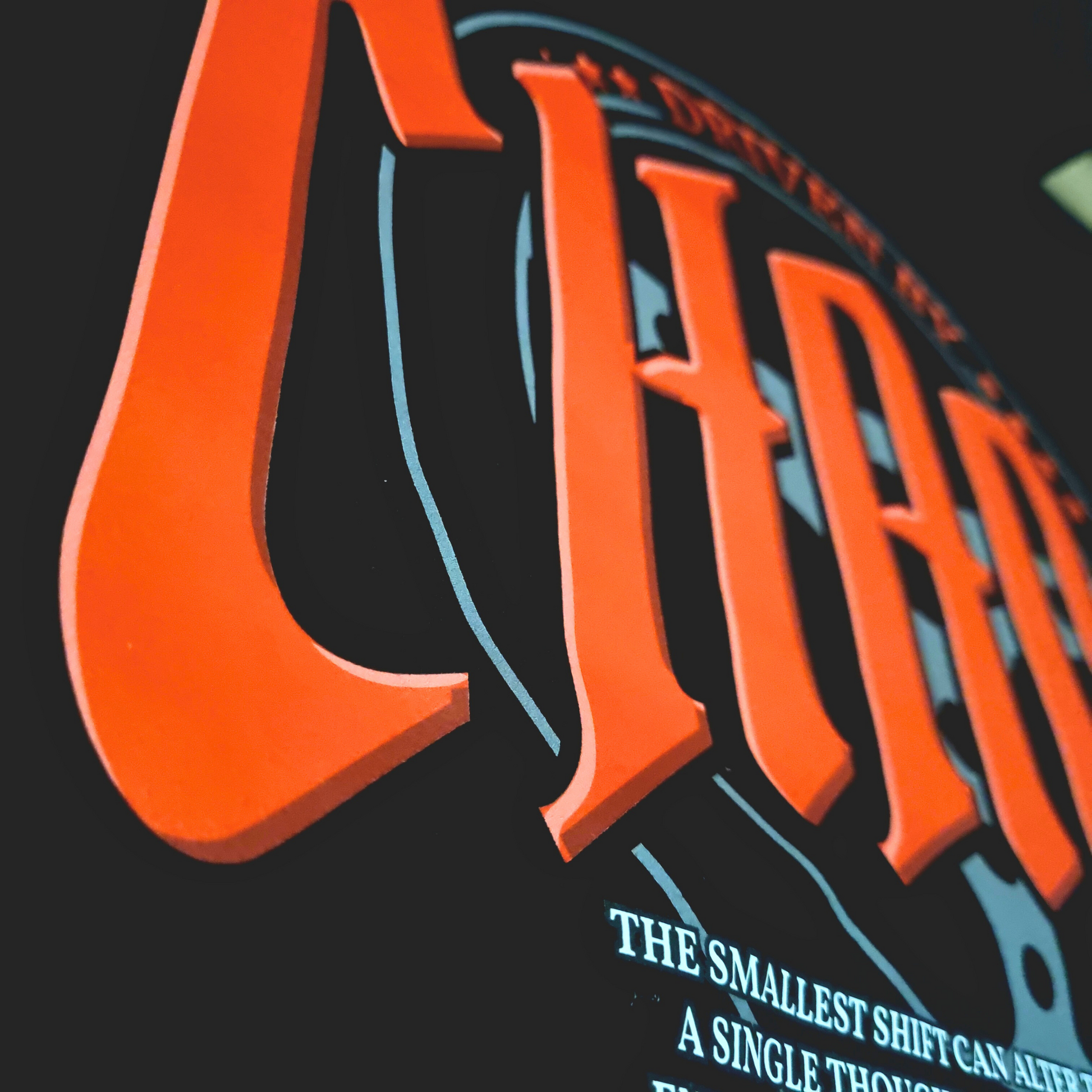Black oversized hoodie with 'DRIVEN BY CHAOS' in large red letters gothic font within a car steering wheel design