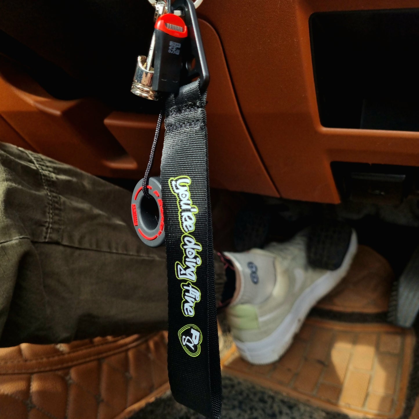 A black key tag with the text 'SLOW DOWN You're Doing Fine' in bold lettering, attached to a metal keychain ring inside Option Pack MAZDA MX5