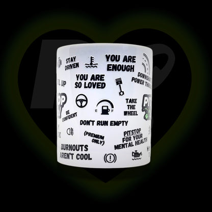 A white ceramic mug with 3D raised text and graphics including the Pitstop Social logo, various symbols and automotive phrases