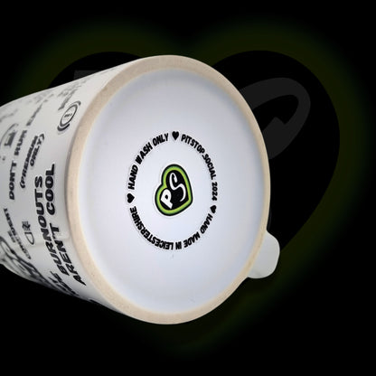 A white ceramic mug with 3D raised text and graphics including the Pitstop Social logo, various symbols, and care instructions at base, made in Leicestershire