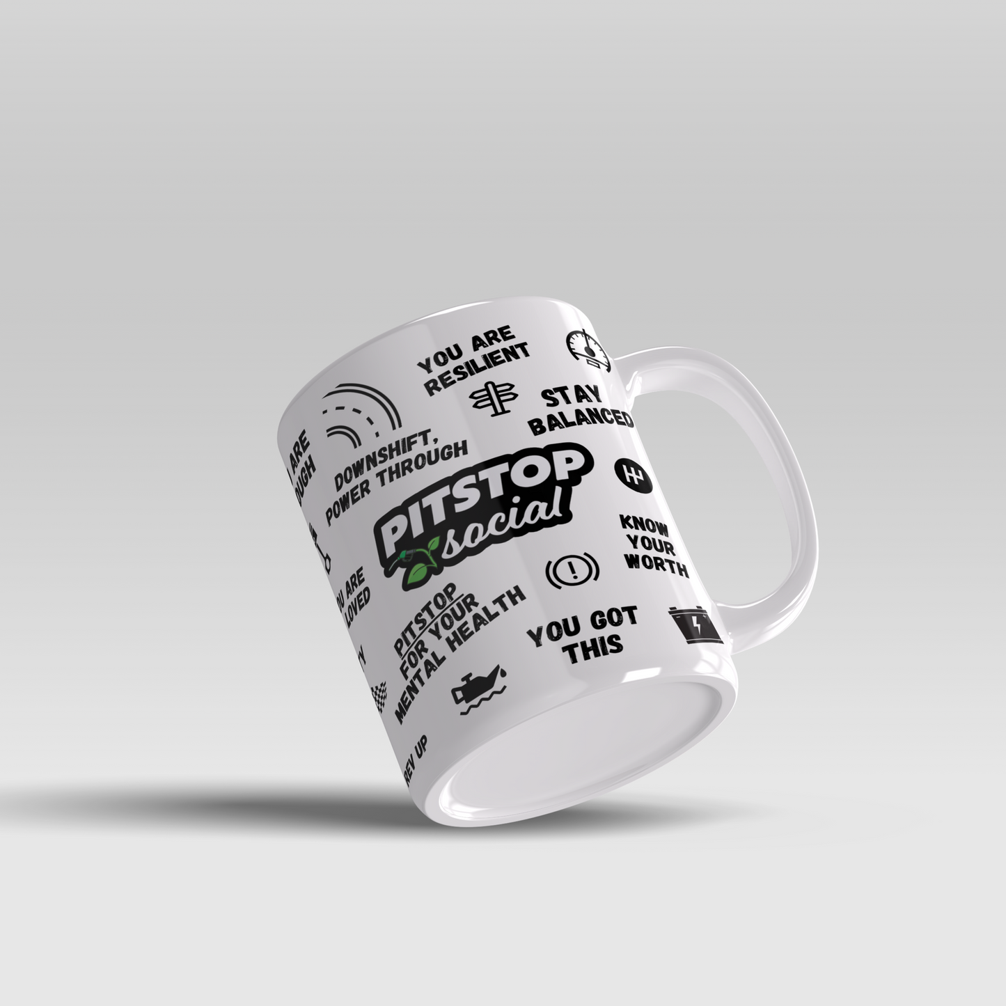 A white ceramic mug with 3D raised text and graphics including the Pitstop Social logo, various car engine symbols