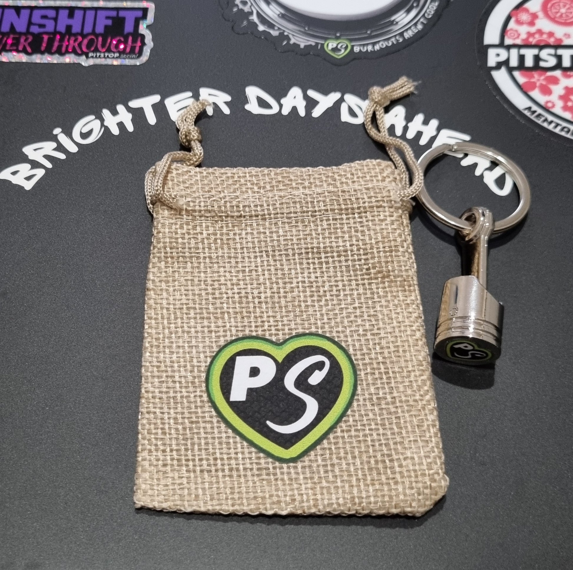 solid metal piston key chain fidget with PITSTOP.Social branded gift bag