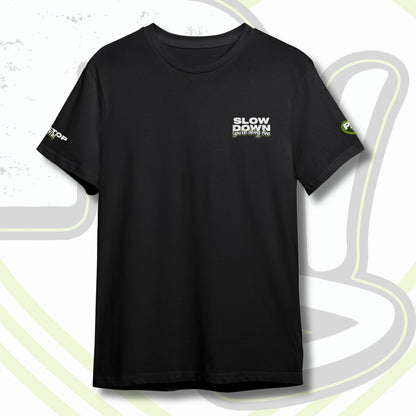 Black graphic t-shirt with graffiti text "SLOW DOWN You're Doing Fine" on front chest and PITSTOP.Social logo on sleeves