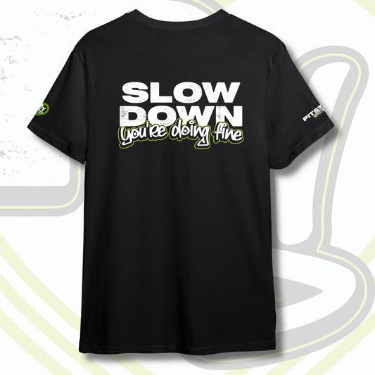 Black graphic t-shirt with graffiti text "SLOW DOWN You're Doing Fine" with green outline and PITSTOP.Social logo on sleeves